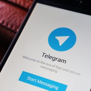Foto eines Smartphones auf dem der Startbildschirm der App "Telegram" zu sehen ist.